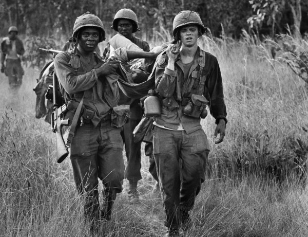 U.S. cavalrymen carry a fellow soldier to an evacuation zone after he was seriously wounded in a North Vietnamese ambush in South Vietnam's Ia Drang Valley, mid November 1965. (Peter Arnett/AP Photo)